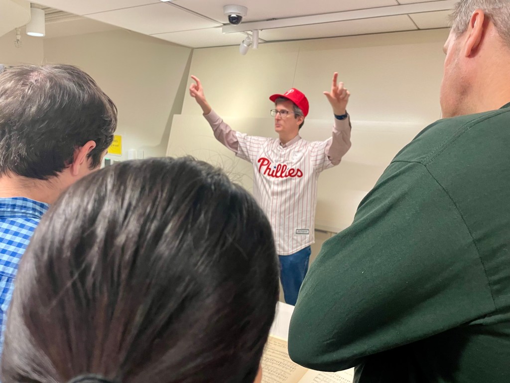 Dank Linke, in Phillies cap and jersey, speaking to class.