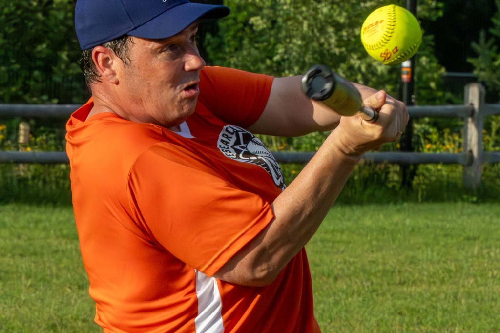 Close-in look at batsman making contact with the softball.