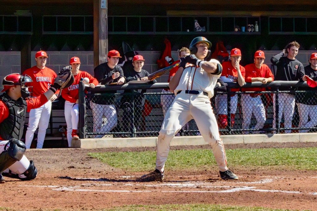 Princeton batter leans back as a high-and-tight pitch brushes him back. The ball has gone past the hitter and is inches away from the catcher's outstretched mitt.