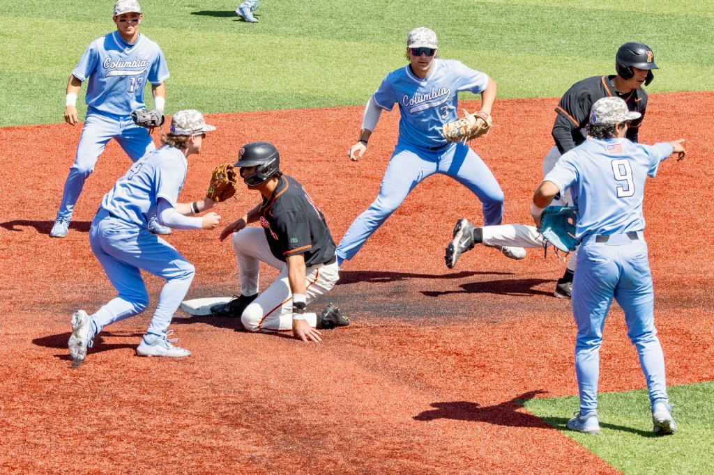 Columbia infielders cluster around second base, where two Princeton runners ended up nearly simultaneously as part of dual rundowns.

