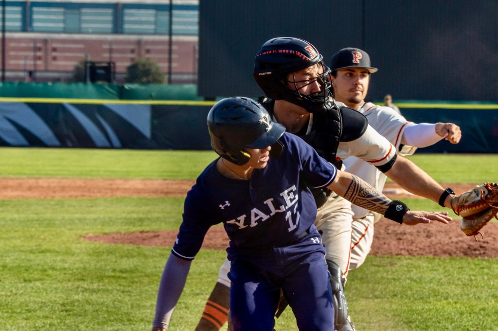 A Yale runner, the Princeton catcher and the Princeton first baseman appear stacked up near home plate on a bunt play.