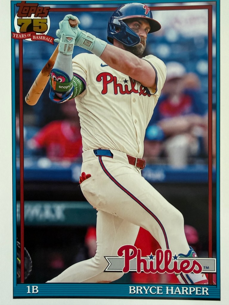 Bryce Harper baseball card, showing him finishing a swing in a white Philadelphia Phillies home uniform. 