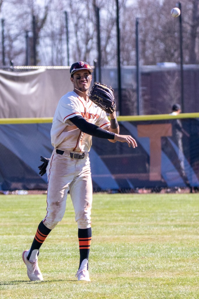 Scott Bandura, wearing a Princeton uniform, tosses a warm-up ball in the outfield at Clarke Field.